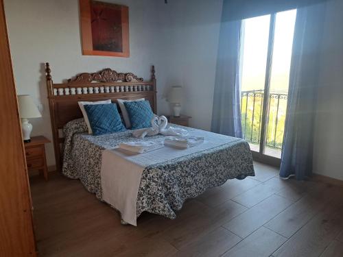 1 dormitorio con 1 cama con almohadas azules en Hostal Breñaverde en Gaucín