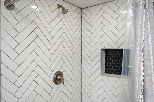 a bathroom with a shower with a white chevroniled wall at Vibrant 3BD in SylvanHills Near Southside Beltline in Atlanta