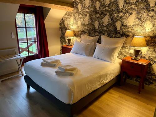 een slaapkamer met een bed met twee handdoeken erop bij Domaine du Grand Nouer in Pierrefitte-sur-Sauldre