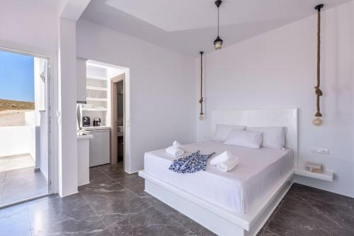a white bedroom with a bed and a kitchen at Alisahni Studio Sea View in Paleochori