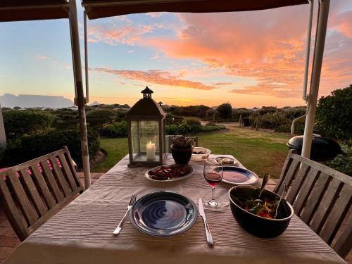 a table with a plate of food and a bowl of food at Dolphin Beach Cabana in Table View