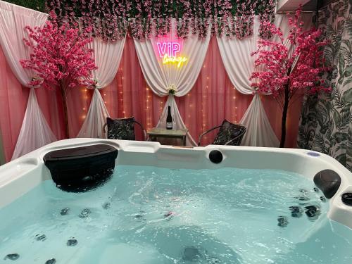 a jacuzzi tub in a room with pink flowers at Cleomack View, Annex apartment with Hot Tub in Hilltown