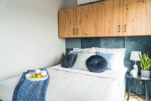a bed with pillows and a tray of fruit on it at Otulina Błonie in Klukowo