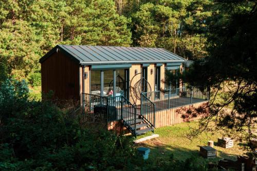 a small cabin with a porch and a deck at Otulina Błonie in Klukowo