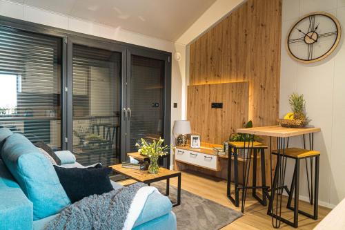 a living room with a blue couch and a kitchen at Otulina Błonie in Klukowo