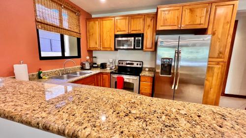 a kitchen with wooden cabinets and stainless steel appliances at Monte Carlo Luxury Condominiums in Jacó