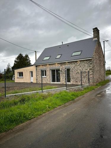 ein Backsteinhaus mit Solardach auf einer Straße in der Unterkunft Gîte de Monthardrou in Le Bény-Bocage