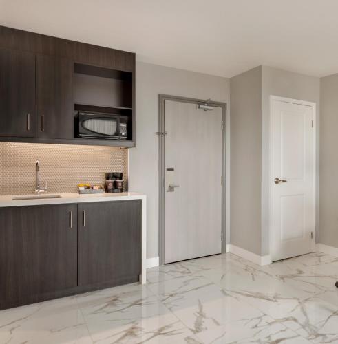 a kitchen with a white door and a counter top at Embassy Suites By Hilton Montreal Airport in Pointe-Claire