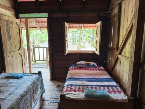 a bedroom with two beds in a wooden house at HOSPEDAJE DOÑA NEL in El Valle