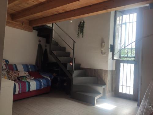 a bedroom with a staircase next to a bed and a window at Piccola Oasi in Catania