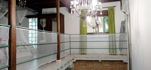 a glass hallway with a chandelier and a staircase at Dúplex Ca tío Celso in San Esteban de la Sierra