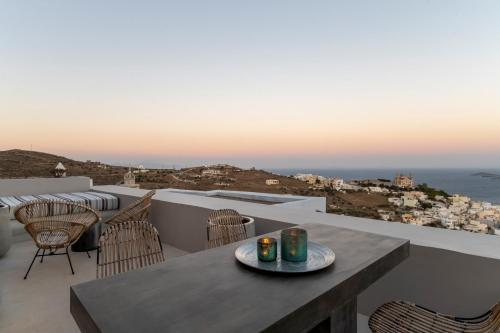 a table on a balcony with a view of the ocean at Glaukopis Retreat in Ano Syros