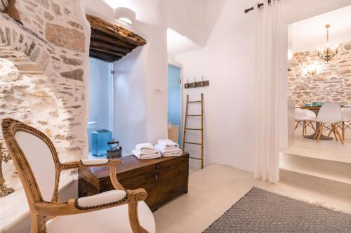 a room with a chair and a table and stairs at Glaukopis Retreat in Ano Syros