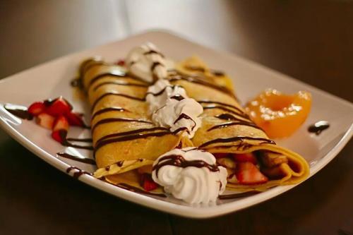 a plate of waffles with ice cream and fruit at Montreal Restful Nights, Adventure Days await! in Montréal