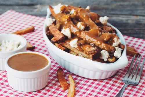 a bowl of food with fries and a dipping sauce at Montreal Restful Nights, Adventure Days await! in Montréal