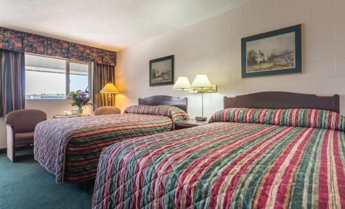 um quarto de hotel com duas camas e uma janela em Grama's Inn em Prince George