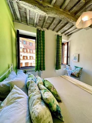 a large bed with pillows in a room with a window at La casa dei Mimmi in Città della Pieve