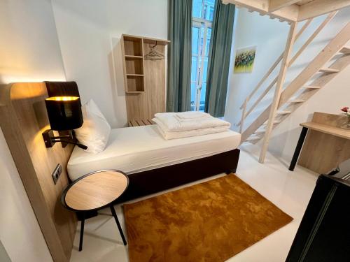 a small room with a bed and a staircase at Adlzreiter City Pension in Munich