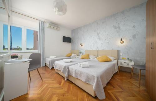 a bedroom with two beds and a table and chairs at Meri Rooms in Vodice
