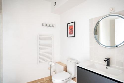 une salle de bain avec toilettes, lavabo et miroir dans l'établissement Les terrasses du Vallon, à Marseille
