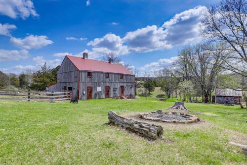 an old barn in a field with a fire pit at Spacious and Historic Cabin in New Haven with Pond! in New Haven