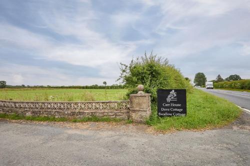 a sign on a fence next to a road at LetAway - Dove Cottage Pickering in Pickering