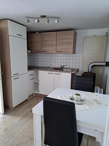 a kitchen with a white table and chairs and a white table and cabinets at Nensi in Ehekirchen