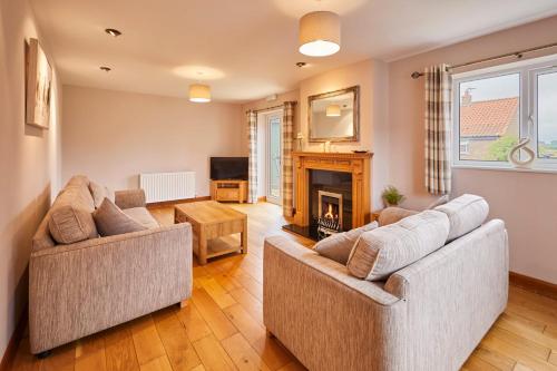 a living room with two couches and a fireplace at LetAway - Dove Cottage Pickering in Pickering