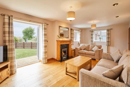 a living room with a fireplace and a tv at LetAway - Dove Cottage Pickering in Pickering