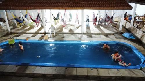a group of people playing in a swimming pool at Pousada Vela dos Ventos in Praia de Moitas