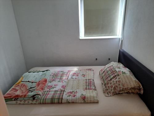 a bed with two pillows on it with a window at Nensi in Ehekirchen