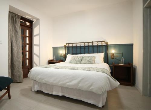 a bedroom with a large bed with a blue headboard at Boutique Hotel La Carriona in Sangolquí