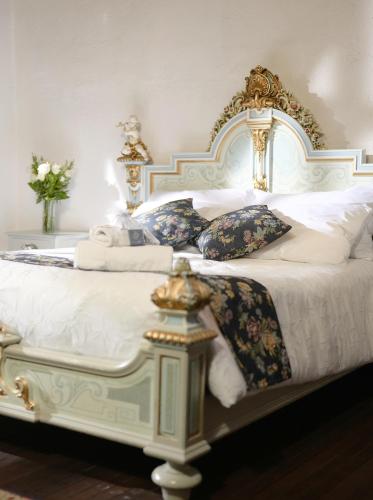 a bedroom with a white bed with pillows at Boutique Hotel La Carriona in Sangolquí