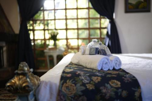 a bedroom with a bed with towels and a window at Boutique Hotel La Carriona in Sangolquí