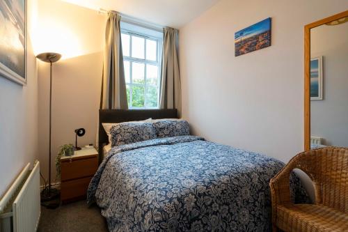 a bedroom with a bed and a chair and a window at Central, Stylish, & Modern Flat in Belfast