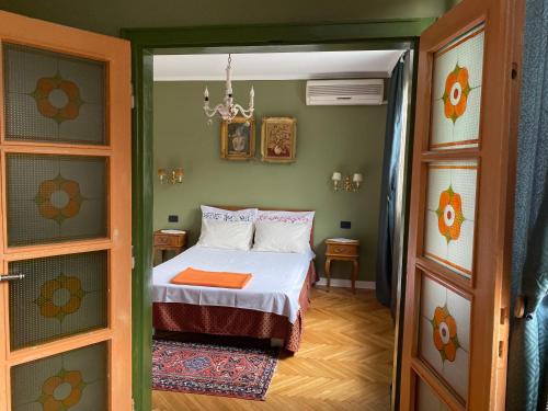 Kleines Zimmer mit einem Bett und einer Tür in der Unterkunft Vintage Apartment in Pristina