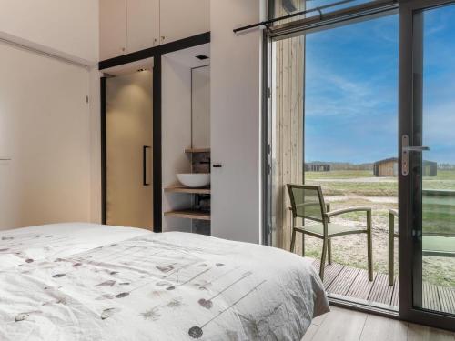 WissenkerkeにあるCottage near Het Bokkegat Nature Reserveのベッドルーム1室(ベッド1台、窓、椅子付)