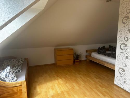 a attic room with a bed and a dresser at Ferienwohnung Soe in Wittenbeck