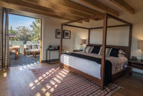 a bedroom with a canopy bed and a patio at La Casa Rodavento in Valle de Bravo