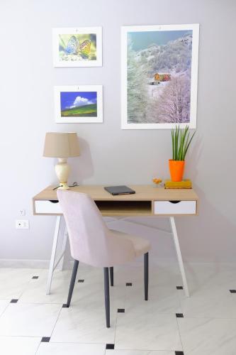 a desk with a white chair and pictures on the wall at La Residenza del Marchesato in Marano Marchesato