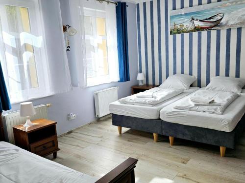 a bedroom with two beds and two windows at Holiday Home in Kolczewo near Baltic Beaches in Kołczewo