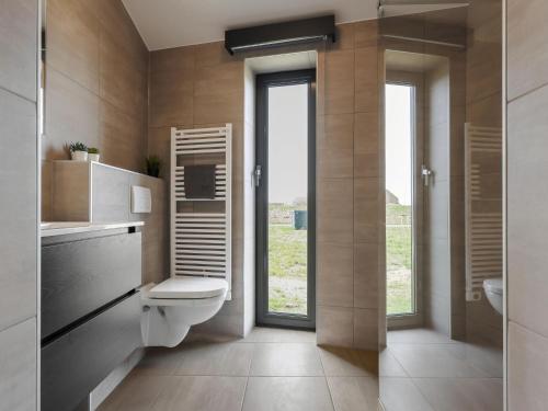 een badkamer met toilet en glazen deur bij Cottage in Wissenkerke near Banjaard Beach in Wissenkerke