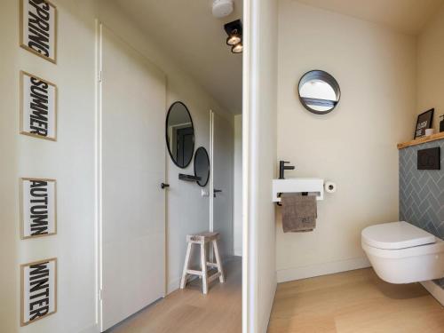 een badkamer met een toilet en een spiegel bij Beautiful holiday home with garden in Wissenkerke