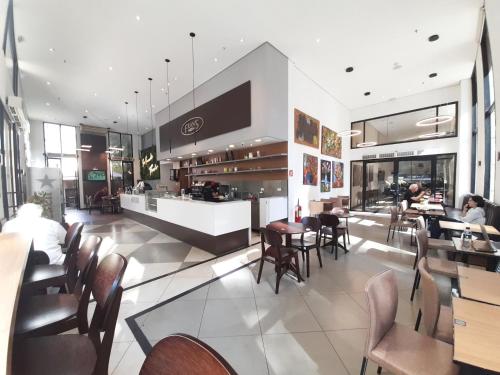 a restaurant with tables and chairs and a bar at EXCELENTE Flat proximo ao Shopping Ibirapuera in Sao Paulo