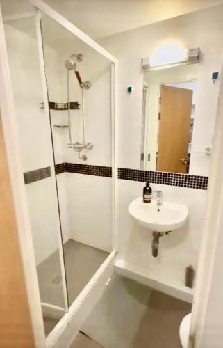 W łazience znajduje się prysznic i umywalka. w obiekcie Kings Cross Beautiful Studio w Londynie