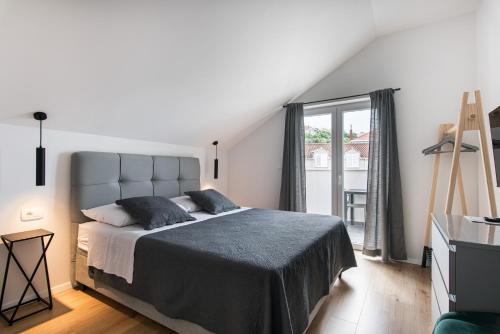 Un dormitorio con una cama grande y una ventana en Apartments Muller en Mlini