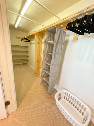 an empty walk in closet with a shelf and shoes at City View Retreat 2 BR 1 B in Draper