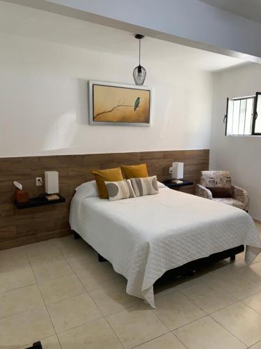 a bedroom with a large white bed and a chair at Casa Don Agus in Guanajuato