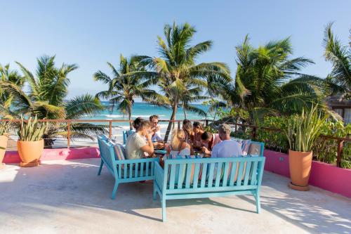 um grupo de pessoas sentadas numa mesa na praia em La Zebra Boutique Hotel em Tulum