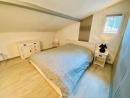 une chambre avec un lit, une commode et une fenêtre dans l'établissement Charmante maison lacanau océan, à Lacanau-Océan